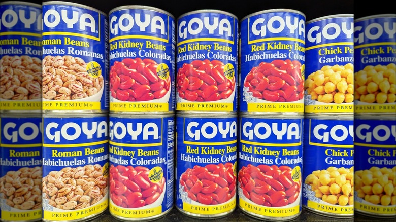 Goya canned beans lined up on grocery store shelf