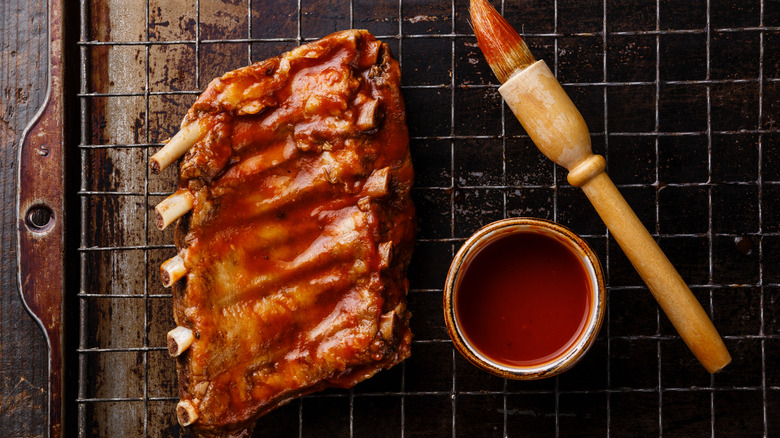 Ribs with barbecue sauce and brush on baking sheet