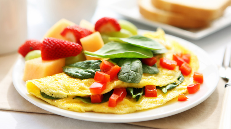 spinach omelet on plate with fruit