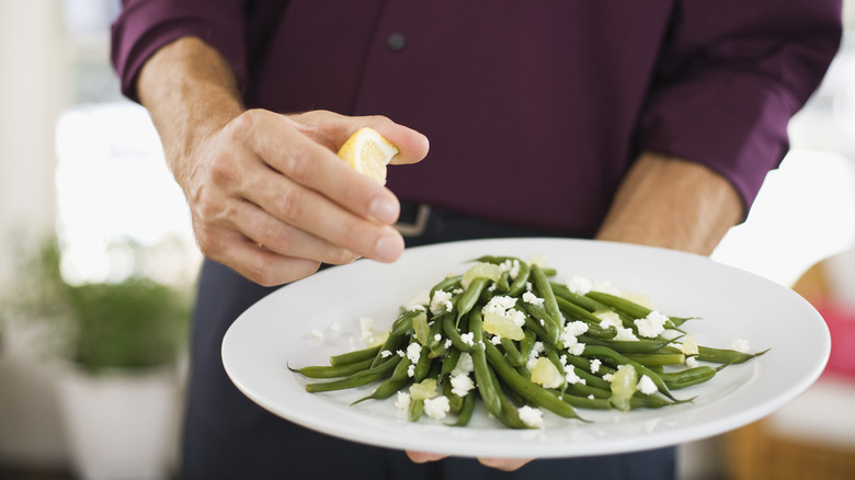 Squeezing lemon over green beans