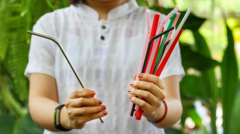 Woman holding steel and plastic straws
