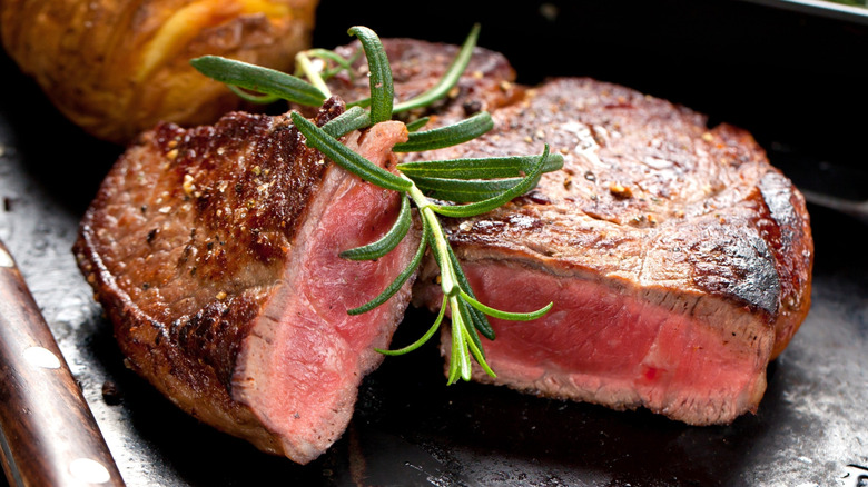A cooked steak has been sliced in half.