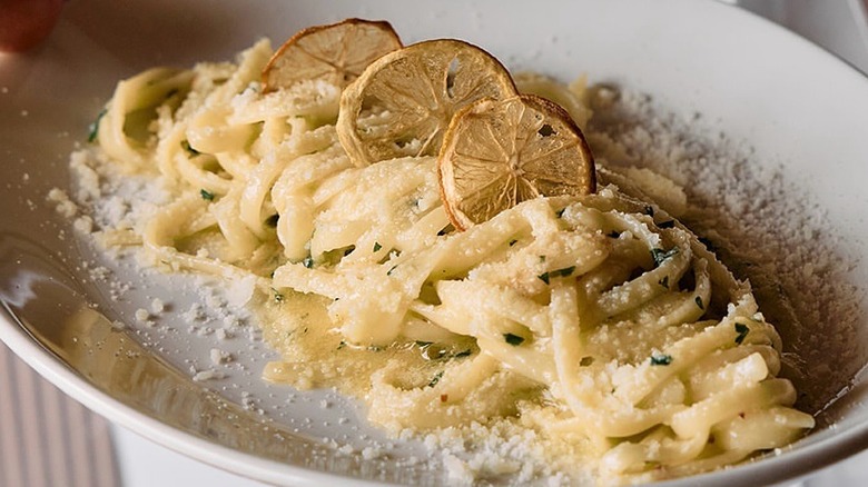 spaghetti in a lemon sauce on a plate with dried lemons on top