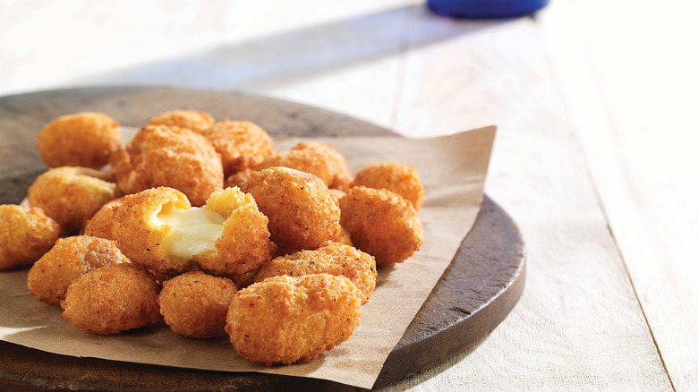 A plate of Culver's cheese curds, with one split in half.