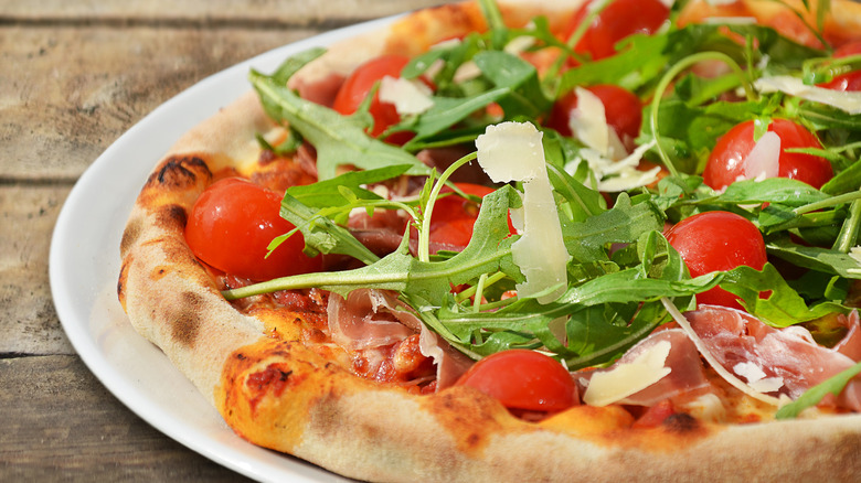 pizza with salad on top