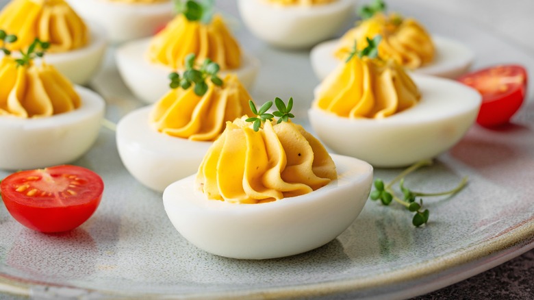 Deviled eggs with cherry tomatoes on plate