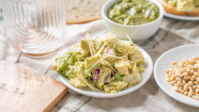 A pesto chicken salad sits in a bowl at a picnic.