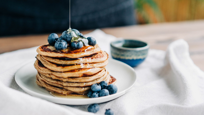 Stack of pancakes with blueberries and maple syrup