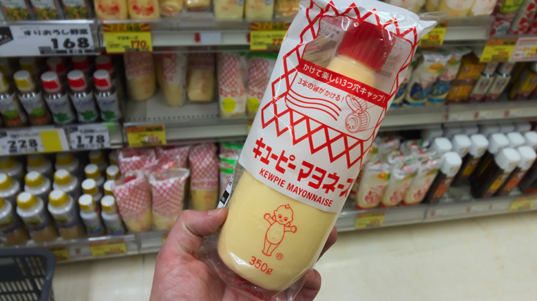 A hand holds Kewpie mayo.
