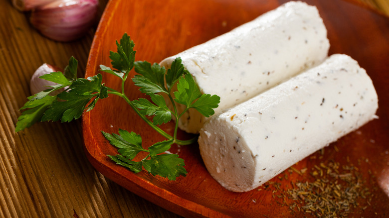 Logs of goat cheese served on a tray.