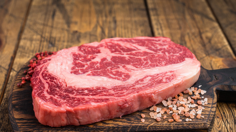 Ribeye steak pictured alongside seasonings.
