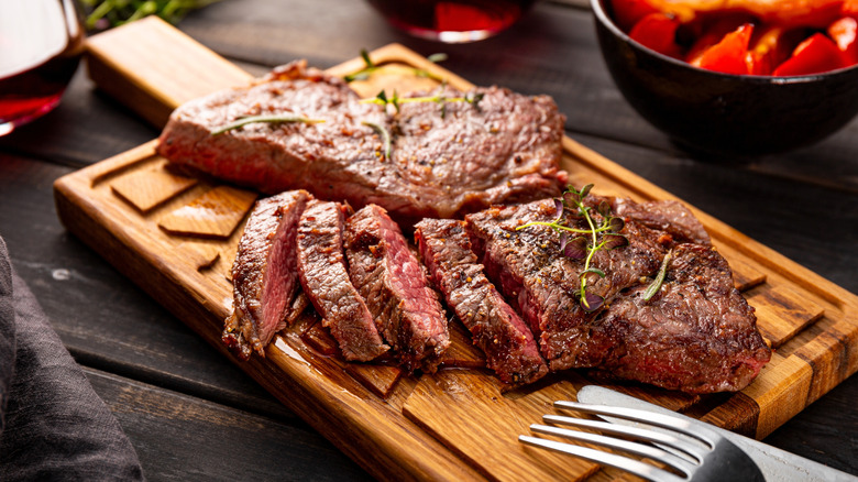 Seasoned ribeye sliced on a serving board.