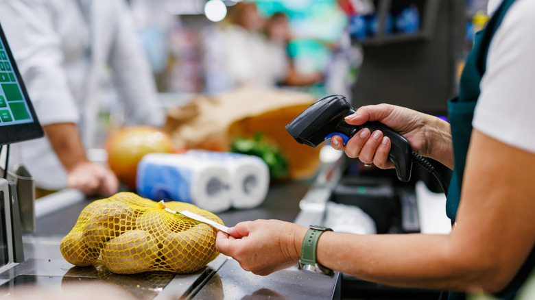 Cashier scanning produce at counter