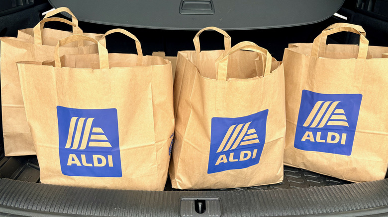 Aldi shopping bags in a car trunk.