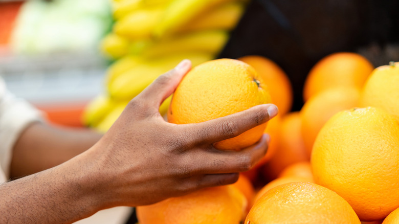 Hands holding an orange