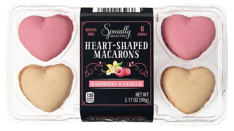 A plastic package of heart-shaped macarons sits against a white background