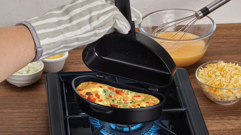 A cook prepares an omelet with a Crofton omelet pan