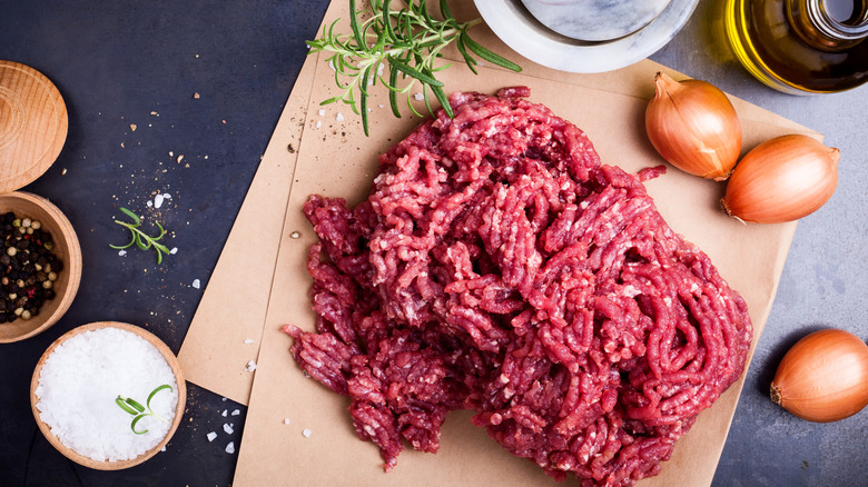 Ground beef on a cutting board with ingredients