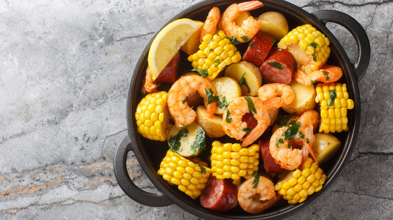 Seafood boil with shrimp, corn, sausage, and potatoes in pot