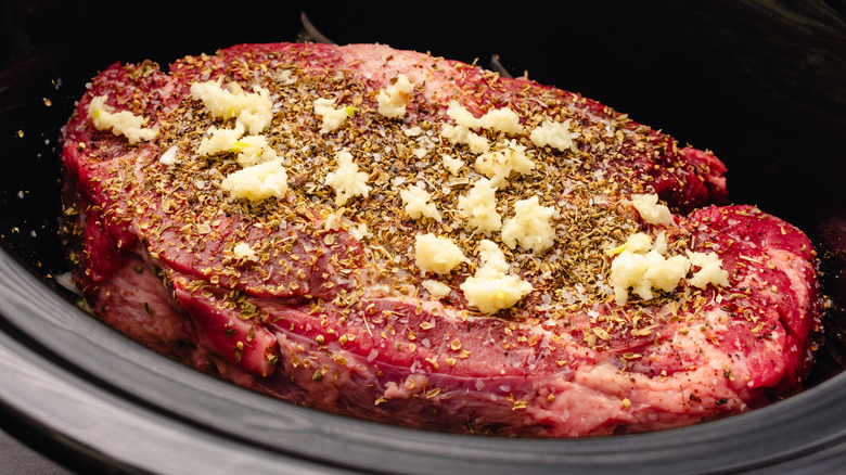Raw chuck roast sitting in a crockpot