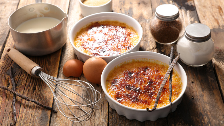 creme brulee and its ingredients on wooden table