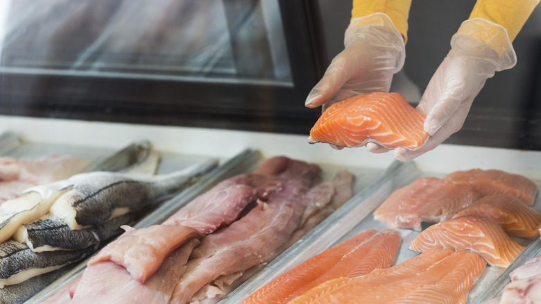 assortment of raw fish filets in display case