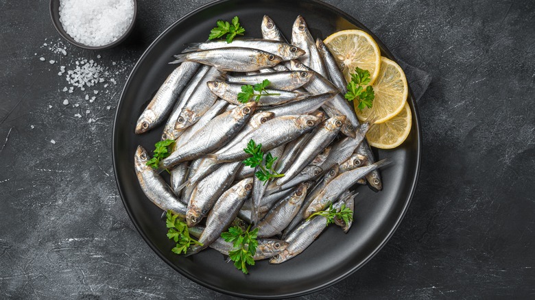 sardines on a plate with parsley and lemon 