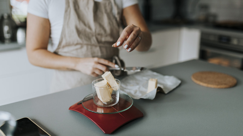 A home baker weighing out a block of butter for a baking project
