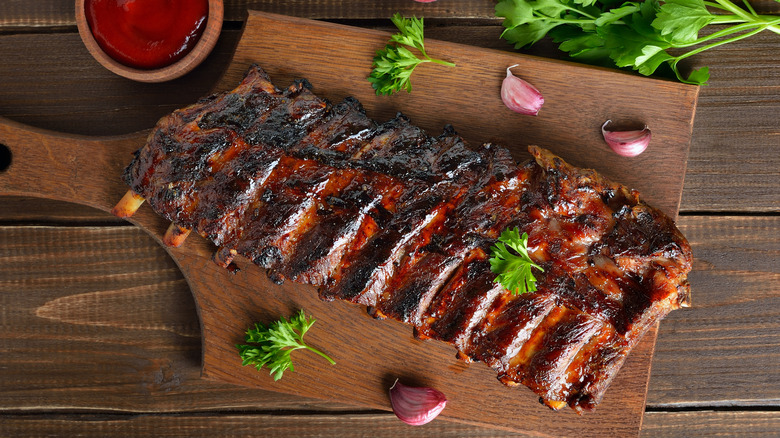 Saucy barbecue ribs on a wooden serving board