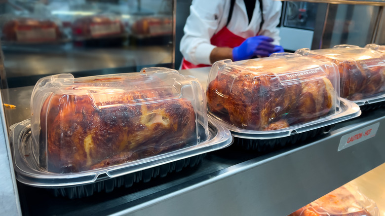 Rotisserie chickens sit in plastic packages in a grocery store