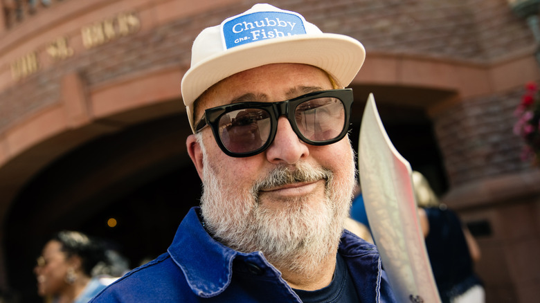 Andrew Zimmern smiles at an event.