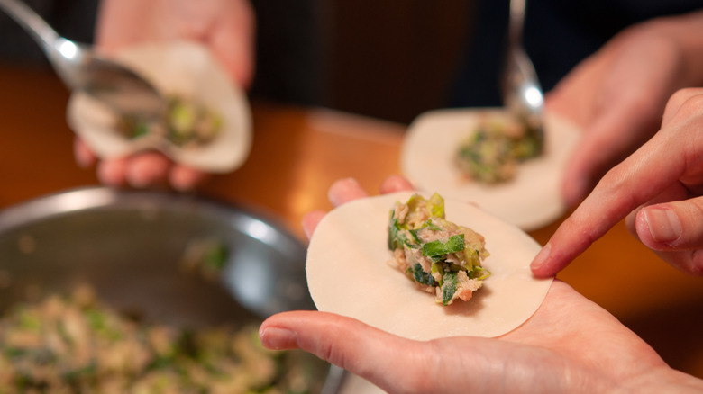 a person wrapping dumplings