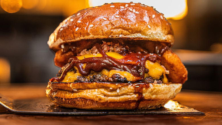 A smash burger with multiple toppings and sauces