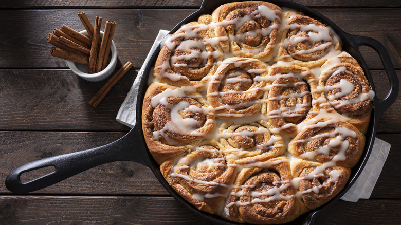 Glazed cinnamon rolls in a cast iron pan