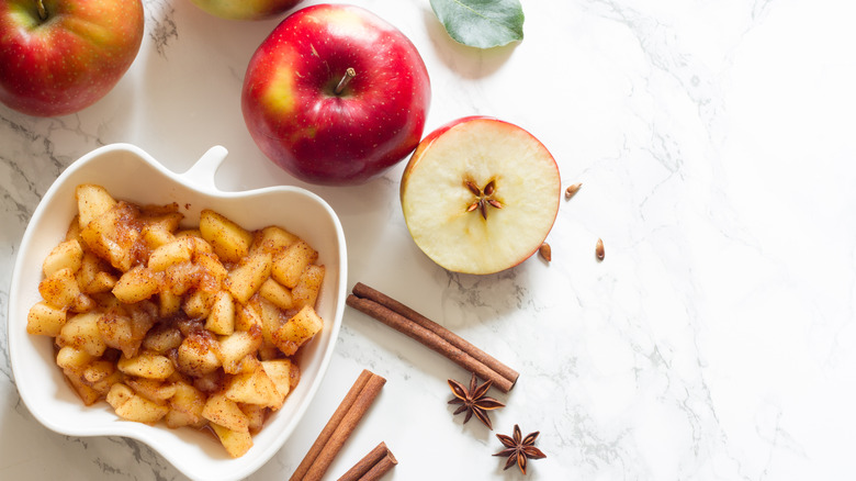 Apples and spices served on a counter.