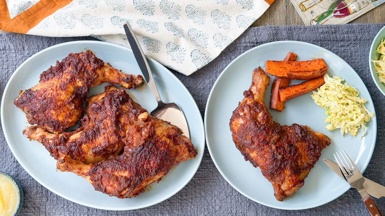 Applesauce barbecue chicken leg quarters on serving plater and plate with sides.