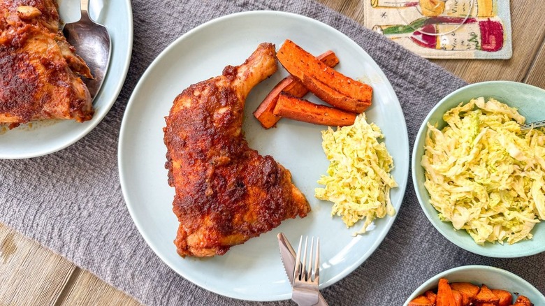 Applesauce barbecue chicken on plate and in pan with side dishes