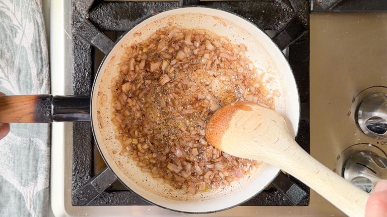 Chopped shallots cooking in brown butter in saucepan on stovetop