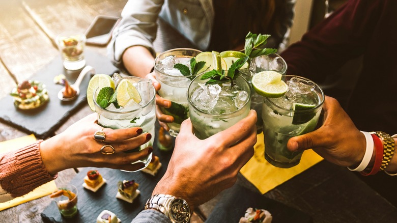 group toasting glasses of mojitos