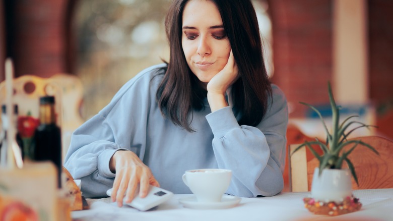 woman putting down phone on table