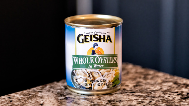A tin of Geisha brand whole canned oysters on a kitchen counter
