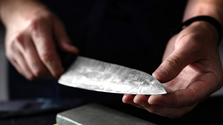 person sharpening a kitchen knife
