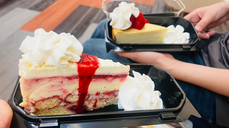 Two slices of cheesecake from The Cheesecake Factory are shown side by side in separate takeout containers
