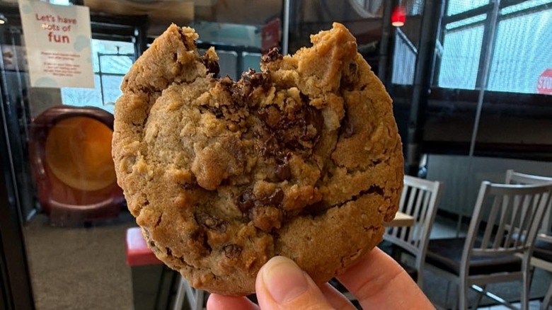 A hand holds a Chick-fil-A cookie.