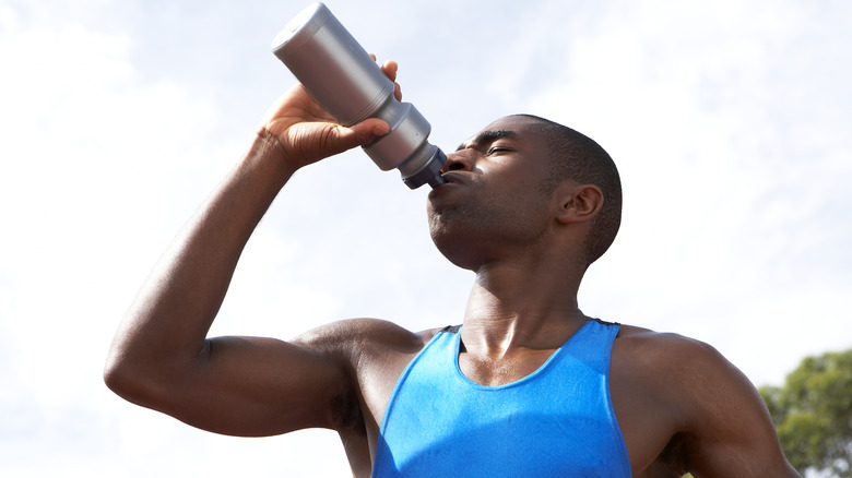 athlete rehydrating with water bottle