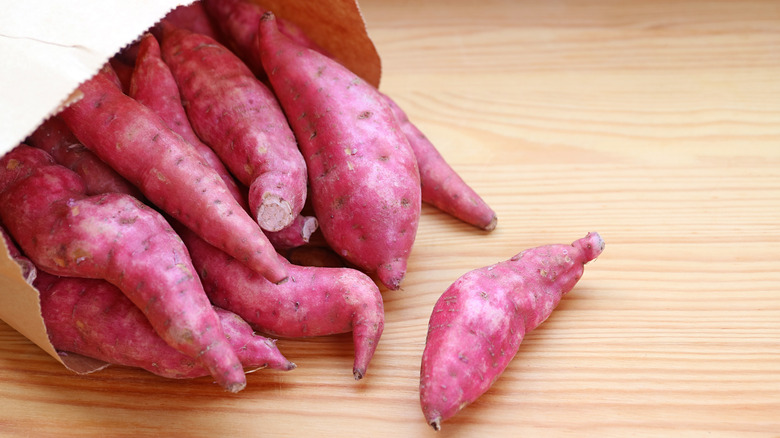 Sweet potatoes spilling out of a paper bag