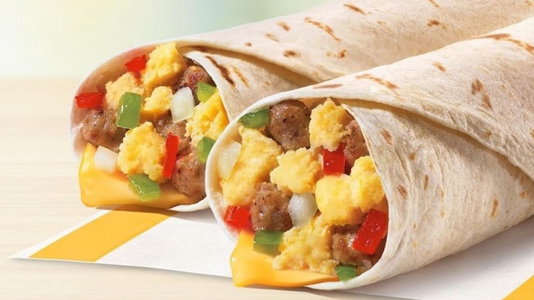 McDonald's breakfast sandwiches on yellow wrapping next to a McCafé cup