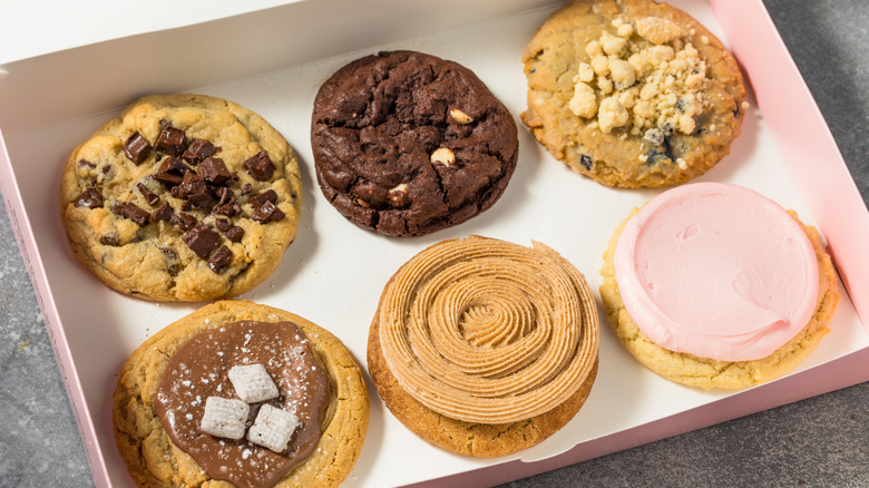 A box filled with several types of Crumbl cookies.