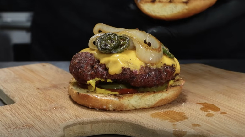 An open-faced brisket burger topped with cheese and onions