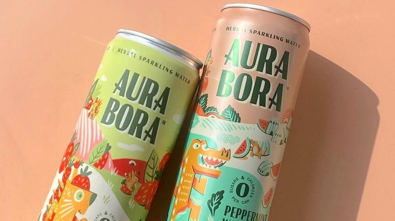 Aura Bora's cans lying on a peach background